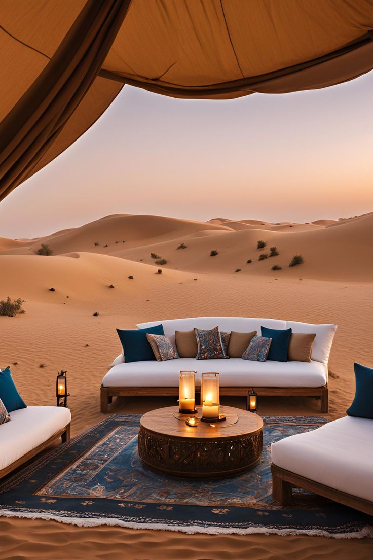 Salón de lujo en el desierto con sofá, velas y dunas al atardecer